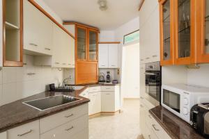 a kitchen with white cabinets and a sink at Downtown apartment 3BDR with city view in Giv‘at Rambam