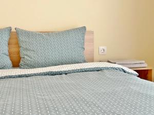 a bed with blue and white sheets and pillows at Central Flat & Free Parking in Varna City