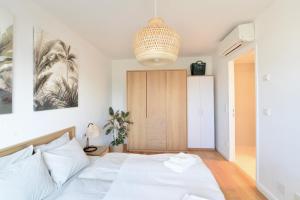 1 dormitorio con cama blanca y lámpara colgante en Modern & Stylish Close to Centre, en Viena