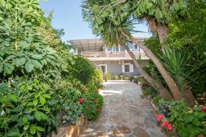 a garden with flowers and plants in front of a house at SOHORO Forest Hill Apartment by "elite" in Kampion