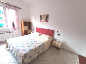 um quarto com uma cama com uma cabeceira vermelha em Casa SOFIA La Spezia em La Spezia