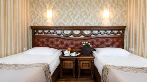 una camera d'albergo con due letti e un tavolo di Hotel Lviv a Lviv