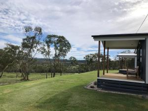 a house with a bench on a grass field at rokkwell in Ballandean
