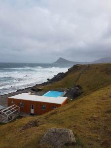Un edificio su una collina vicino all'oceano di Bergistangi Hostel a Norðurfjörður