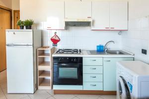 uma cozinha branca com um fogão e um lavatório em SE002 - Senigallia, bilocale fronte mare con spiaggia em Senigallia