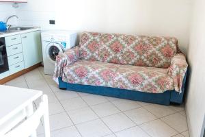 um sofá numa cozinha com uma máquina de lavar roupa em SE002 - Senigallia, bilocale fronte mare con spiaggia em Senigallia