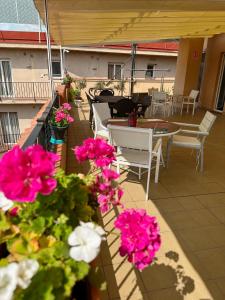 a balcony with tables and chairs and pink flowers at Royal Inn Aparthotel in Lloret de Mar