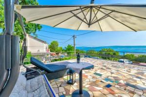 德拉马利Apartman Draga的天井配有遮阳伞、椅子和桌子