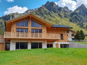 een houten huis met een berg op de achtergrond bij Gargellen Lodge in Gargellen