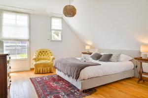 1 dormitorio con 1 cama y 1 silla en Magnolia - Charmante maison avec jardin, en Nantes