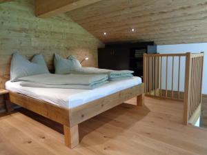 1 dormitorio con 1 cama con sábanas y almohadas blancas en Gargellen Lodge, en Gargellen