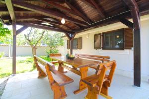 a wooden table and chairs on a patio at House Stella 1319 in Valtura