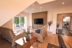 a living room with a couch and a table at 118qm Premium Apartment - Birkenfeld National Park in Ellweiler
