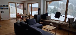 uma sala de estar com um sofá azul e uma grande janela em Gargellen Lodge em Gargellen