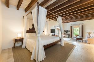 a bedroom with a bed with a canopy at Hotel Rural Son Mas - 4* in Porto Cristo