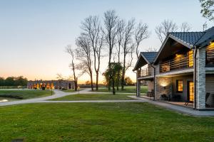 a building with a pathway next to a grass field at Reketijos Dvaras in Reketija