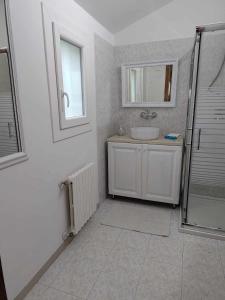 a white bathroom with a sink and a shower at TRAGHETTO VECCHIO HOUSE in Cavallino-Treporti