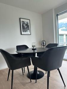 a black table and chairs in a room with a window at Village by Maier - kontaktloser Check-in in Hohenems
