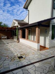 a house with a stone patio in front of it at TRAGHETTO VECCHIO HOUSE in Cavallino-Treporti