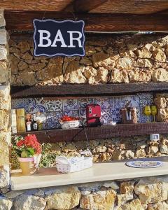 a bar sign hanging on a stone wall at Case Vacanza Zeus in Trappeto