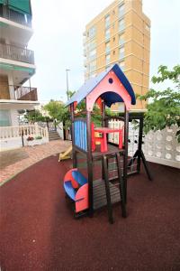 un parque infantil con una estructura de juegos en una alfombra en Precioso apartamento con piscina WiFi, en La Pobla de Farnals