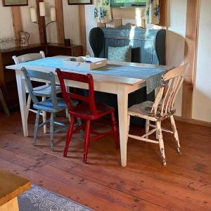 une table en bois avec quatre chaises et une boîte sur celle-ci dans l'établissement Forest Garden Shovelstrode, à East Grinstead