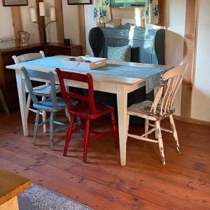 a wooden table with four chairs and a box on it at Forest Garden Shovelstrode in East Grinstead