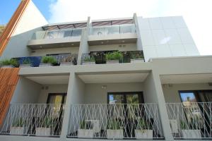 メルボルンにあるメルローズ アパートメンツの植物が植えられたバルコニー付きの建物