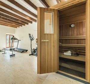 een fitnessruimte met een loopband en een fitnessruimte bij Hotel Rural Son Mas - 4* in Porto Cristo