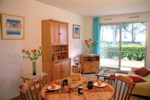 a living room with a table and a dining room at Lagrange Vacances Les Trois Rivières in Mandelieu-La Napoule