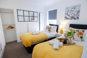 two beds in a room with yellow and white at Cosy Home by the Sea in Great Yarmouth in Southtown