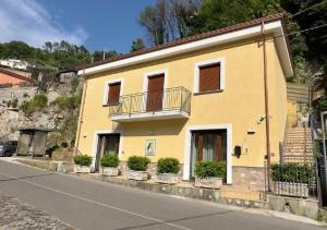 una casa amarilla al lado de una carretera en Appartamenti Santa Rita, en Maiori