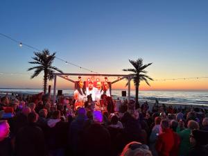 een menigte mensen die een band zien optreden op het strand bij Wave Resort & Spa Magic Apartaments with sea view in Międzyzdroje