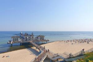 a pier on a beach with people on the beach at Bungalow "Refugium" in Ostseebad Sellin