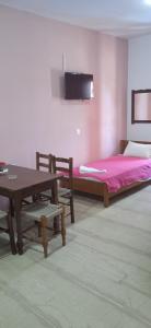 a bedroom with a bed and a table and chairs at EKTOR APARTMENTS @SWIMMING POOL in Sidari