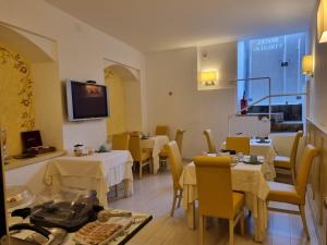 a restaurant with tables and chairs and a tv on the wall at Hotel Virgilio in Orvieto