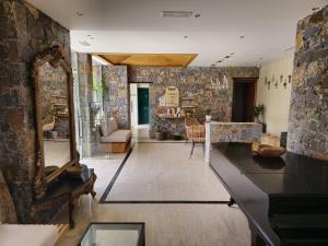 a living room with a mirror and a stone wall at Dias Hotel & Apts in Stalida