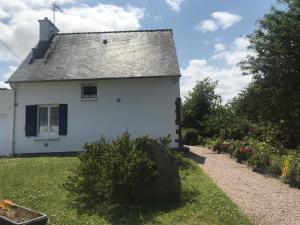 een wit huis met een grijs dak en een tuin bij Maison entière Trélévern in Trélévern