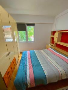 ein Schlafzimmer mit einem farbenfrohen Bett und einem Fenster in der Unterkunft Risteski Inn in Prilep