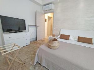a bedroom with a bed and a tv and a chair at Casa Emmeti in Desenzano del Garda