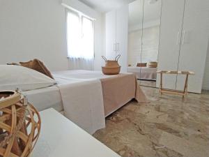 a white room with a bed and a mirror at Casa Emmeti in Desenzano del Garda