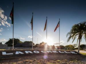 un grupo de banderas delante de un cartel con el sol en La Rochelle Lodge Namibia Tsumeb, en Tsumeb