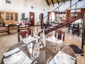 Un comedor con una mesa y una escalera. en La Rochelle Lodge Namibia Tsumeb, en Tsumeb
