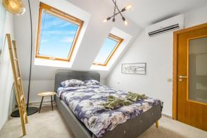 a attic bedroom with a bed and a window at Top Central Maisonette with Underground parking in Sofia