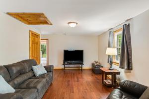 a living room with a couch and a flat screen tv at Moe's Vineyard - Cabin in Necedah