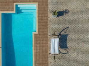 una piscina con una silla y una planta al lado en Piedra Villa en Troïanáta