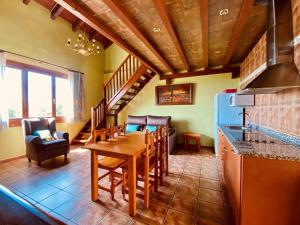 a kitchen and dining room with a table and chairs at Apartamentos Els Ocells in Camprodon