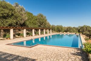 una gran piscina en un patio con árboles en Hotel Rural Son Mas - 4*, en Porto Cristo