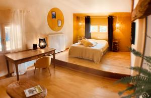 a bedroom with a bed and a desk and a table at Le repaire de la rêveuse in Saint-Frajou