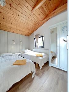 1 dormitorio con 2 camas y techo de madera en Domki u Projektantek, en Władysławowo